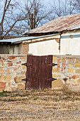 Alte Woden-Tore in einer Steinmauer in San Antonio, einer Kleinstadt im ländlichen New Mexico