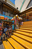 Famous yellow steps leading up to the Mercado Modelo in Santo Domingo, Dominican Republic. A shopkeeper sells drums.