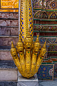 Eine goldene fünfköpfige Naga oder Wassergottheit auf den Stufen des Phra Mondhop im Grand Palace-Komplex in Bangkok, Thailand