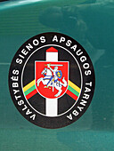The official crest of the Lithuanian State Border Guard Service on a vehicle at the border crossing with Belarus.