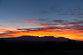Colorful sunrise clouds over the La Sal Mountains and canyon country near Moab, Utah.