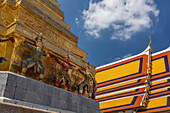 Small yaksha guardian statues at the Temple of the Emerald Buddha complex in the Grand Palace grounds in Bangkok, Thailand. A yaksha or yak is a giant guardian spirit in Thai lore.