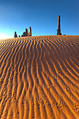 The Totem Pole with animal tracks in rippled sand in the Monument Valley Navajo Tribal Park in Arizona.