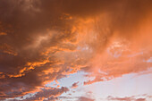Virga or evaporating rain falling from colorful clouds at sunset near Moab, Utah.