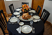 Gedeckter Tisch für ein Thanksgiving-Dinner mit gebratenem Truthahn, englischem Porzellan und Kristallbesteck in Utah