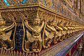 Goldene Statuen von Garuda und Naga bewachen den Tempel des Smaragdbuddhas im Grand Palace in Bangkok, Thailand