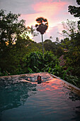 Young attractive woman enjoying a bath in the infinity edge swimming pool at The Dutch House, Galle, Sri Lanka