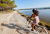 Junge Frau fährt mit dem Fahrrad auf Formentera, Balearen, Spanien