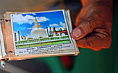 Hand eines Reiseführers zeigt Foto von Thuparamaya, Anuradhapura, Sri Lanka