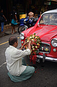 Man decorates wedding car with flowers, Galle, Sri Lanka