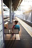 Young woman waits for transfer train to Kansai Airport, Japan