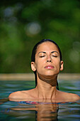 Young attractive woman enjoying a bath in the infinity edge swimming pool at The Dutch House, Galle, Sri Lanka