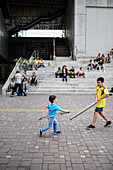 Kids fight with plastic swords outside The Museum of Modern Art of Medellin (MAMM), Colombia