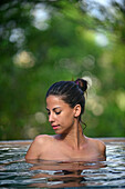 Young attractive woman enjoying a bath in the infinity edge swimming pool at The Dutch House, Galle, Sri Lanka