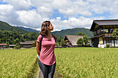 Porträt einer jungen kaukasischen Frau im Freien in Shirakawa-go, einem traditionellen Dorf, das einen als gassho-zukuri bekannten Baustil zeigt, Präfektur Gifu, Japan