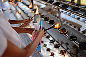 Women light incense in Ruwanwelisaya, a stupa in Anuradhapura, Sri Lanka, considered a marvel for its architectural qualities and sacred to many Buddhists all over the world.