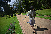 Mann beim Spazierengehen im Victoria Park, einem öffentlichen Park in Nuwara Eliya, Sri Lanka