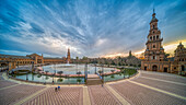 Atemberaubende Dämmerungsszene auf der historischen Plaza de EspaUa mit spiegelnden Wasserflächen, Sevilla, Spanien