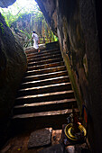Junger Junge erklimmt die Treppe im buddhistischen Tempel Yatagala Raja Maha Viharaya, Unawatuna, Sri Lanka