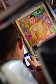 Junger Mann benutzt Smartphone im Bus, Sri Lanka