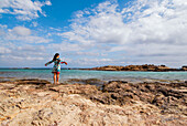 Junge attraktive Brünette atmet am Strand von Formentera, Balearen, Spanien