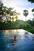 Junge attraktive Frau genießt ein Bad im Infinity-Swimmingpool des The Dutch House, Galle, Sri Lanka