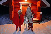 Der Weihnachtsmann posiert mit Elf und Rentier. Das Haus des Weihnachtsmanns im Kakslauttanen Arctic Resort. Lappland, Finnland