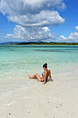 Junge Frau am Strand von Kondoi, Insel Taketomi, Präfektur Okinawa, Japan