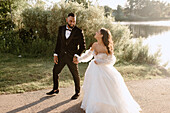 Bride and groom walking on lakeshore