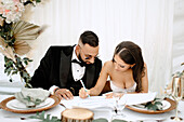 Braut und Bräutigam unterschreiben ihre Heiratsurkunde