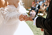 Close-up of bride putting wedding ring on grooms finger