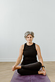 Porträt einer Frau, die zu Hause Yoga übt
