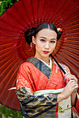 Porträt einer Frau mit Kimono und Sonnenschirm in der Hand