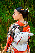 Rückansicht einer Kimono tragenden Frau im Park