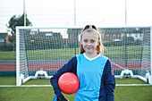 UK, Porträt einer lächelnden Fußballspielerin (12-13) vor einem Tor
