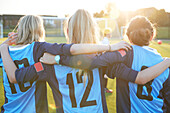 UK, Rückansicht von Fußballspielerinnen (10-11, 12-13), die sich auf dem Feld umarmen