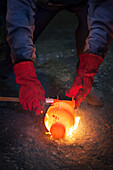 Checking diameter of a still red hot flaming crank shaft with a vernier