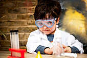 UK, Boy (4-5) making science experiments at home
