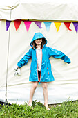 Smiling girl (4-5) in raincoatÊoutside tent