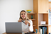 Portrait of smiling young female doctor with laptop