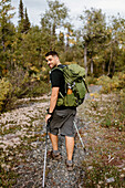 Kanada, Yukon, Whitehorse, Portrait eines lächelnden Mannes beim Wandern im Wald