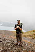 Kanada, Yukon, Whitehorse, Porträt eines lächelnden Mannes beim Wandern in einer nebligen Landschaft
