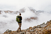 Canada, Whitehorse, Man with backpack hiking in rocky landscape
