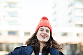 Portrait of smiling woman in knit hat outdoors