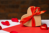 Herzförmige Geschenkschachtel und Valentinstagsdekoration auf dem Tisch
