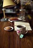 Tee, Keks und Buch auf dem Schreibtisch
