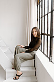 Lächelnde junge Frau auf der Treppe sitzend