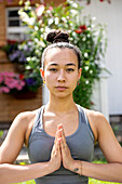 UK, London, Porträt einer meditierenden Frau vor einem Haus