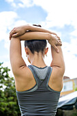 UK, London, Rear view of woman stretching outdoors