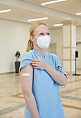 Österreich, Wien, Krankenschwester mit Gesichtsmaske und Heftpflaster am Arm